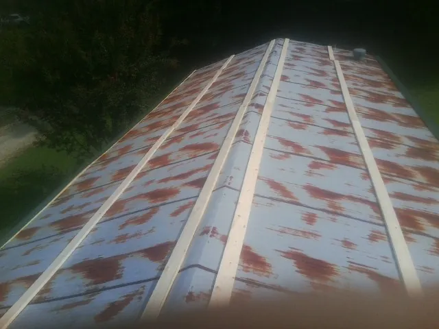 Rusted metal roof panels with new wood purlins before replacement — Storm Damage Roof Repair in Shawnee by Roofing Brothers
